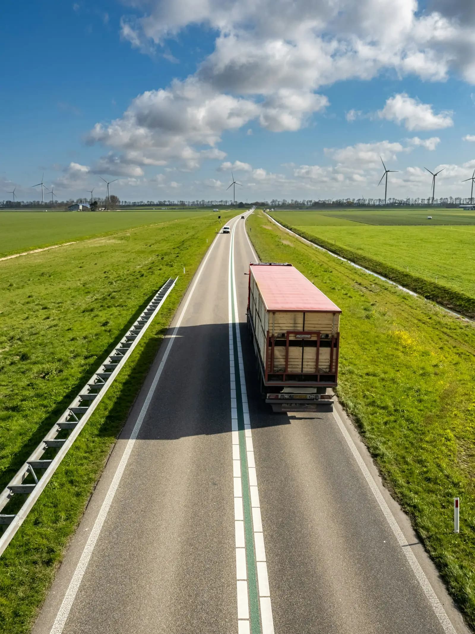 A truck on a country road among wind turbines, seen from above