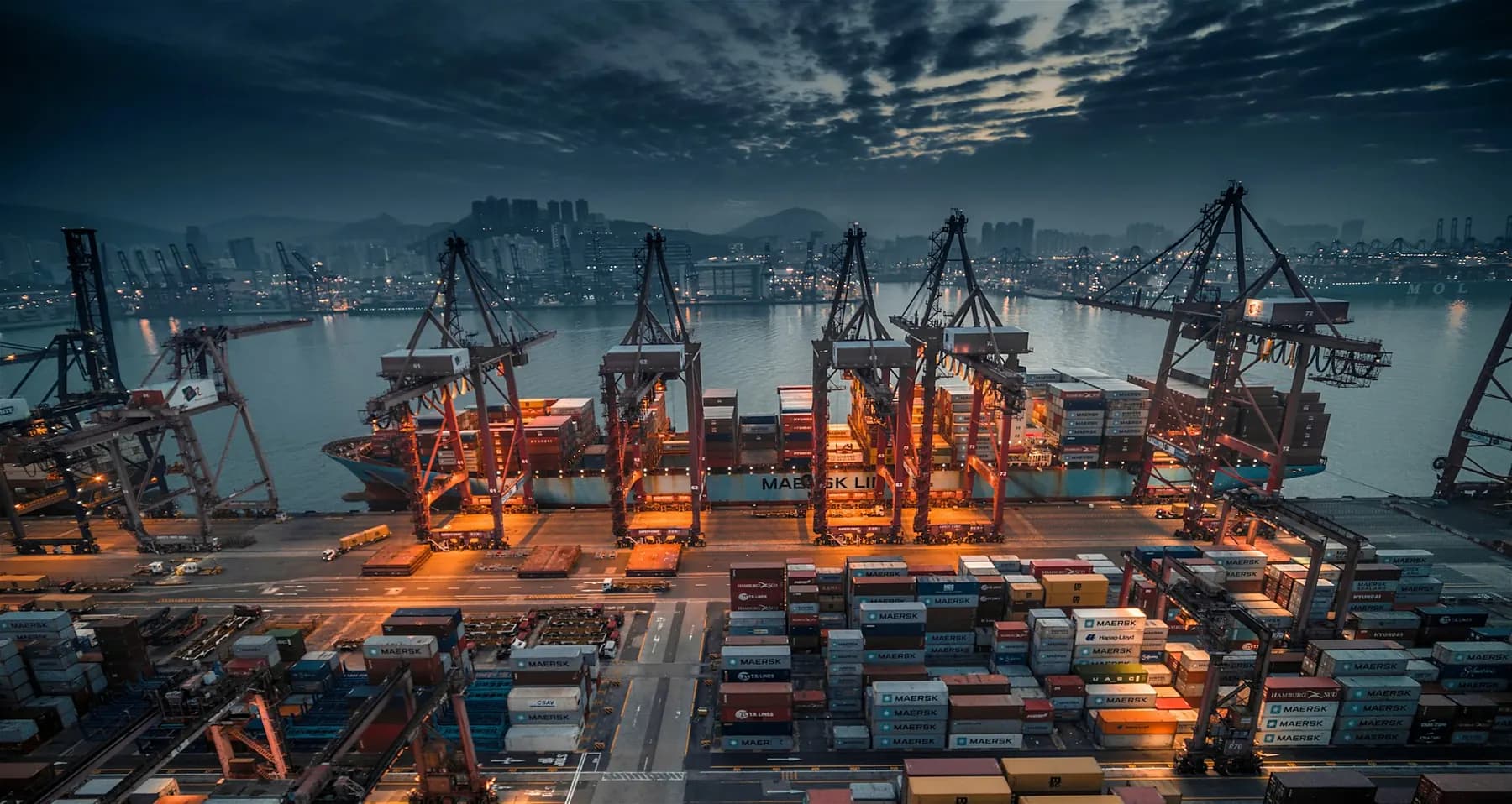 A container port with cranes at dusk